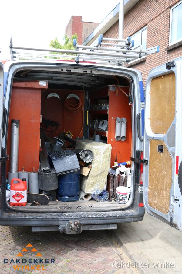 Bedrijfsbus van dakdekker met gereedschap en materialen in Winkel Bedrijfsbus van dakdekker met gereedschap en materialen in Winkel